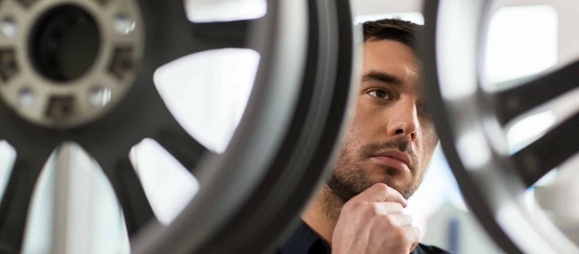 male customer choosing wheel rims at car service