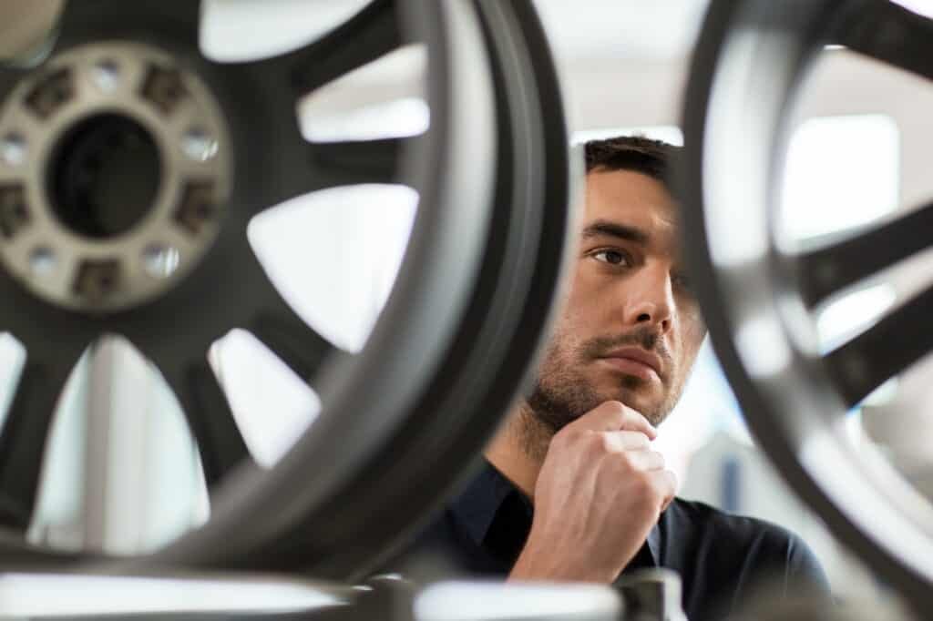 male customer choosing wheel rims at car service