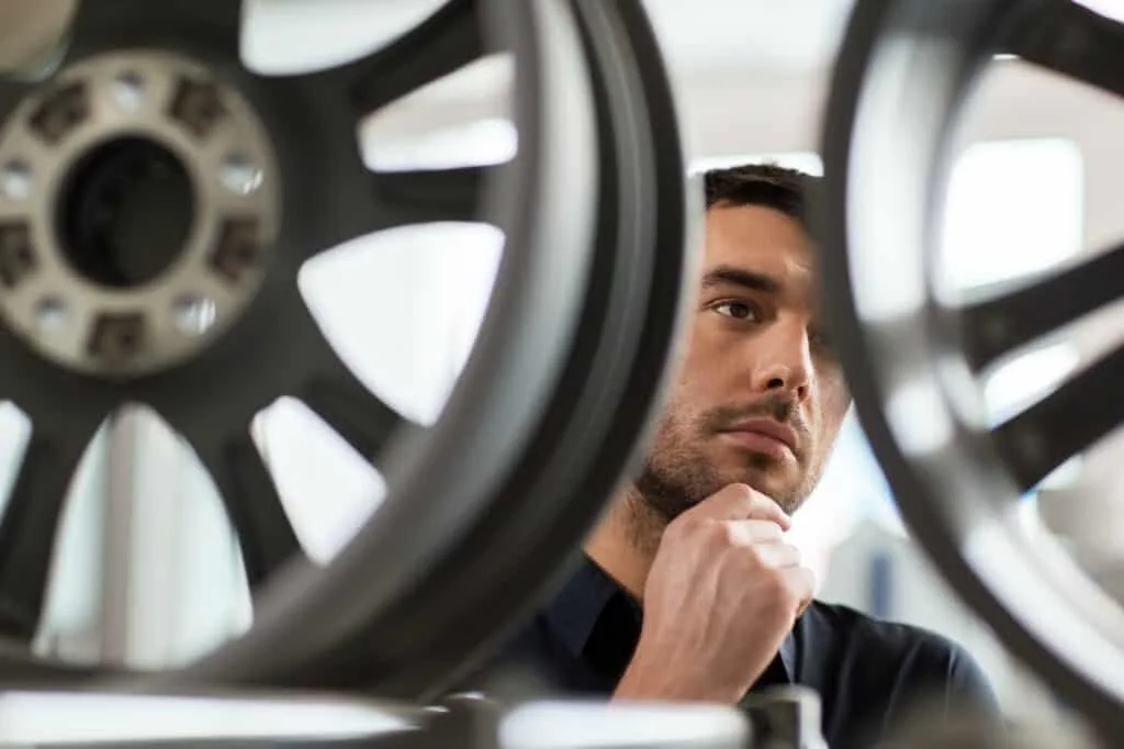 male customer choosing wheel rims at car service